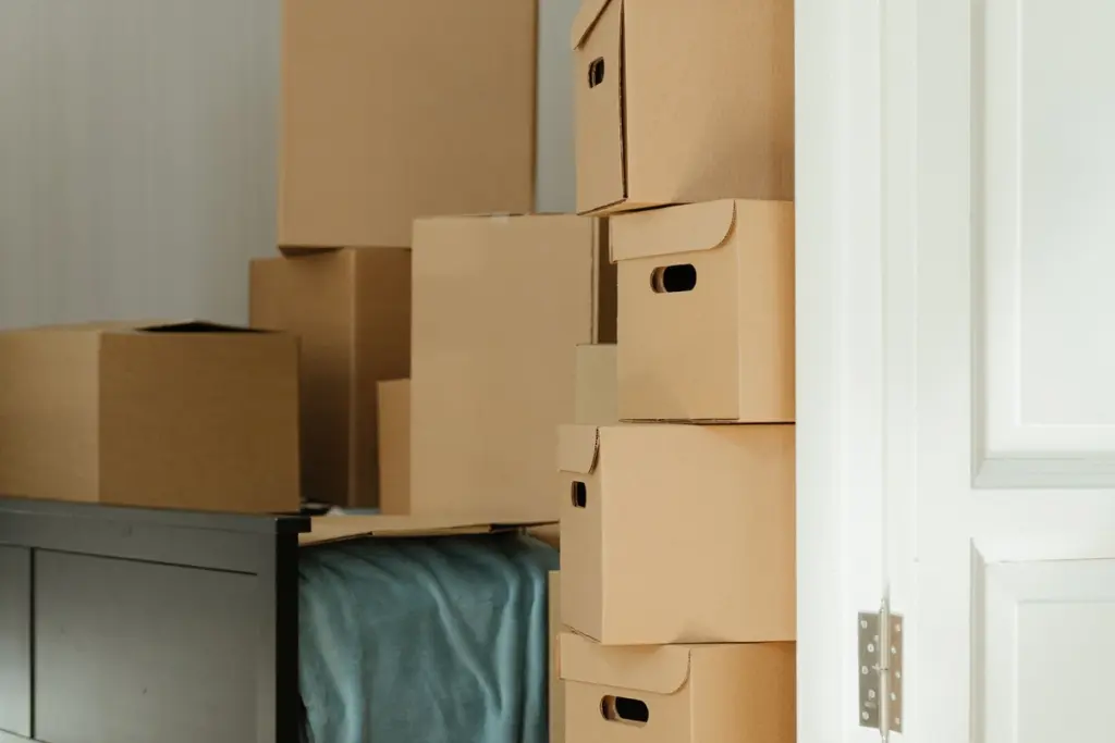 Cajas de cartón apiladas en un dormitorio de una casa que se está vaciando