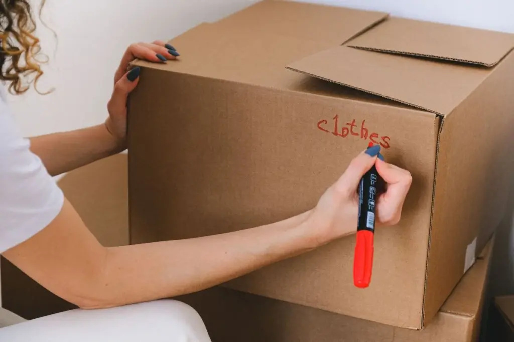 Persona etiquetando una caja de cartón con un rotulador