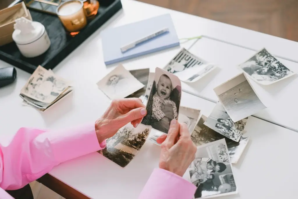 Manos revisando fotos antiguas sobre una mesa antes de vaciar la casa