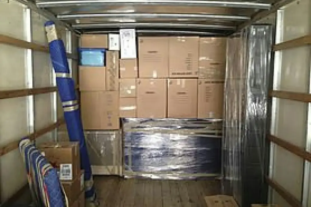 Muebles envueltos en film y cajas cargados dentro de un camión de mudanza